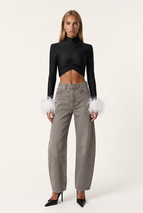 The Saint 54 fitted black long-sleeve top with polo neckline, front gathering, and detachable white ostrich feathers.