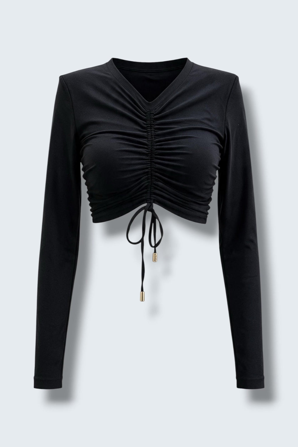 The Saint 54 black long-sleeve crop top with adjustable front ruching, shoulder pads, and gold-tone tie tips.