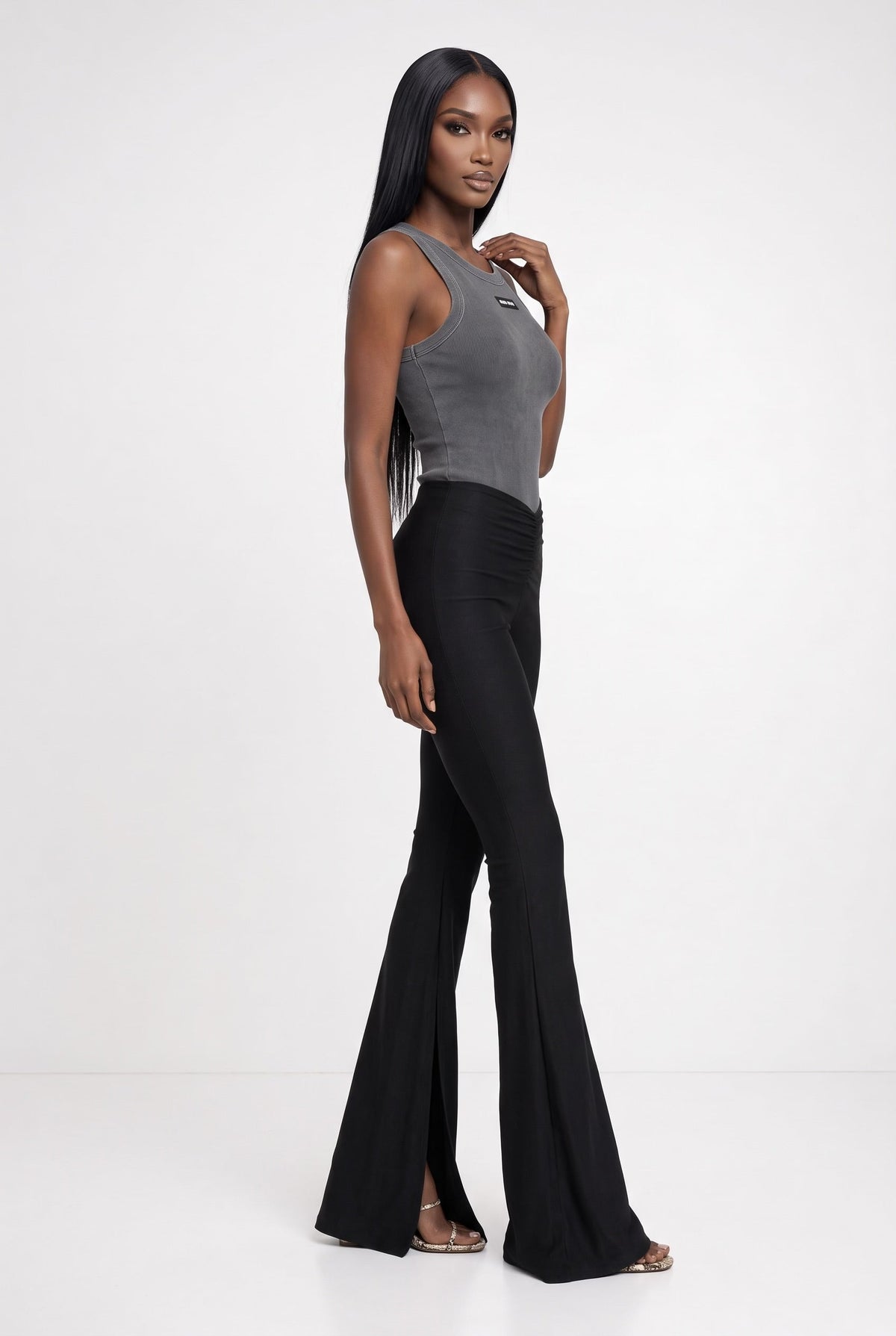 The Saint 54 grey cropped tank top and black high-waisted flared trousers with side slits worn by a model.